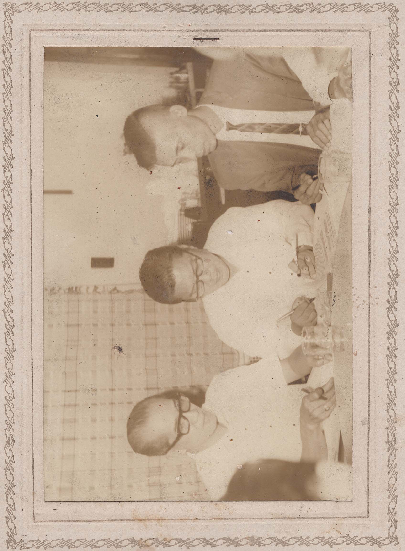 Three men signing documents at a table