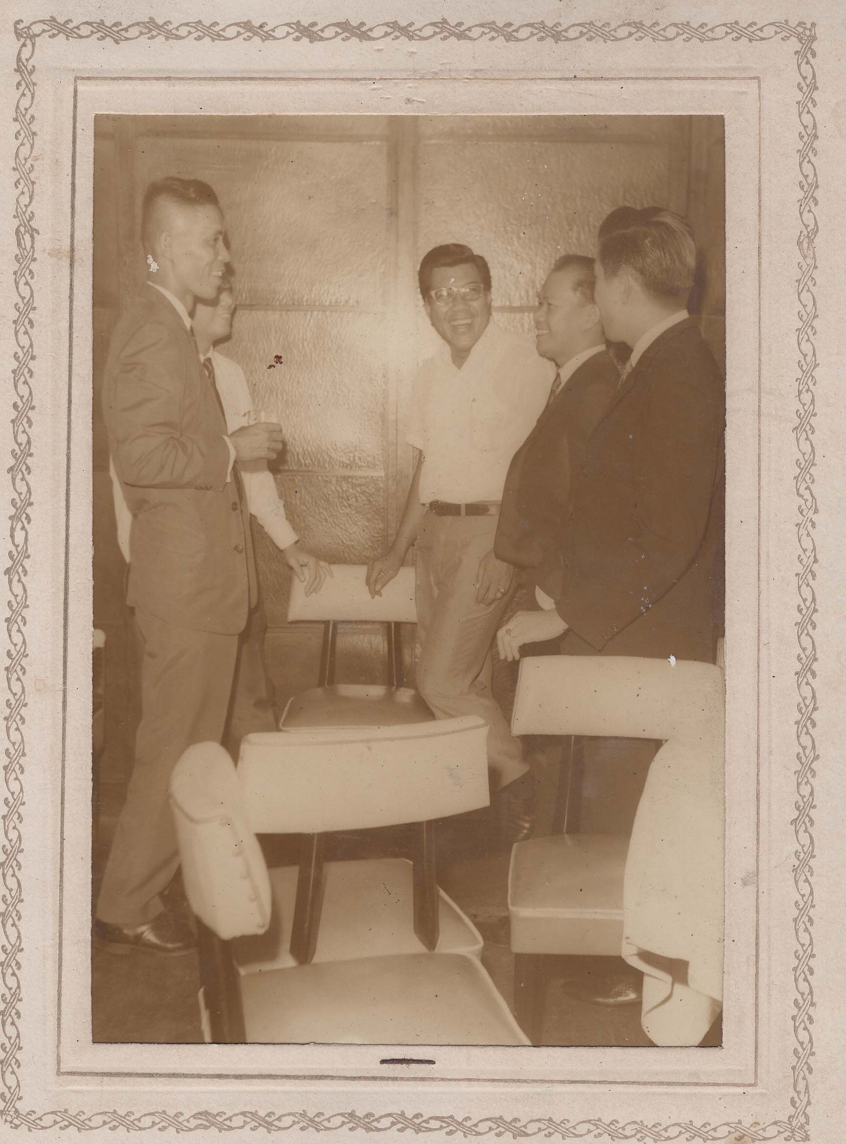 Five men standing and laughing together