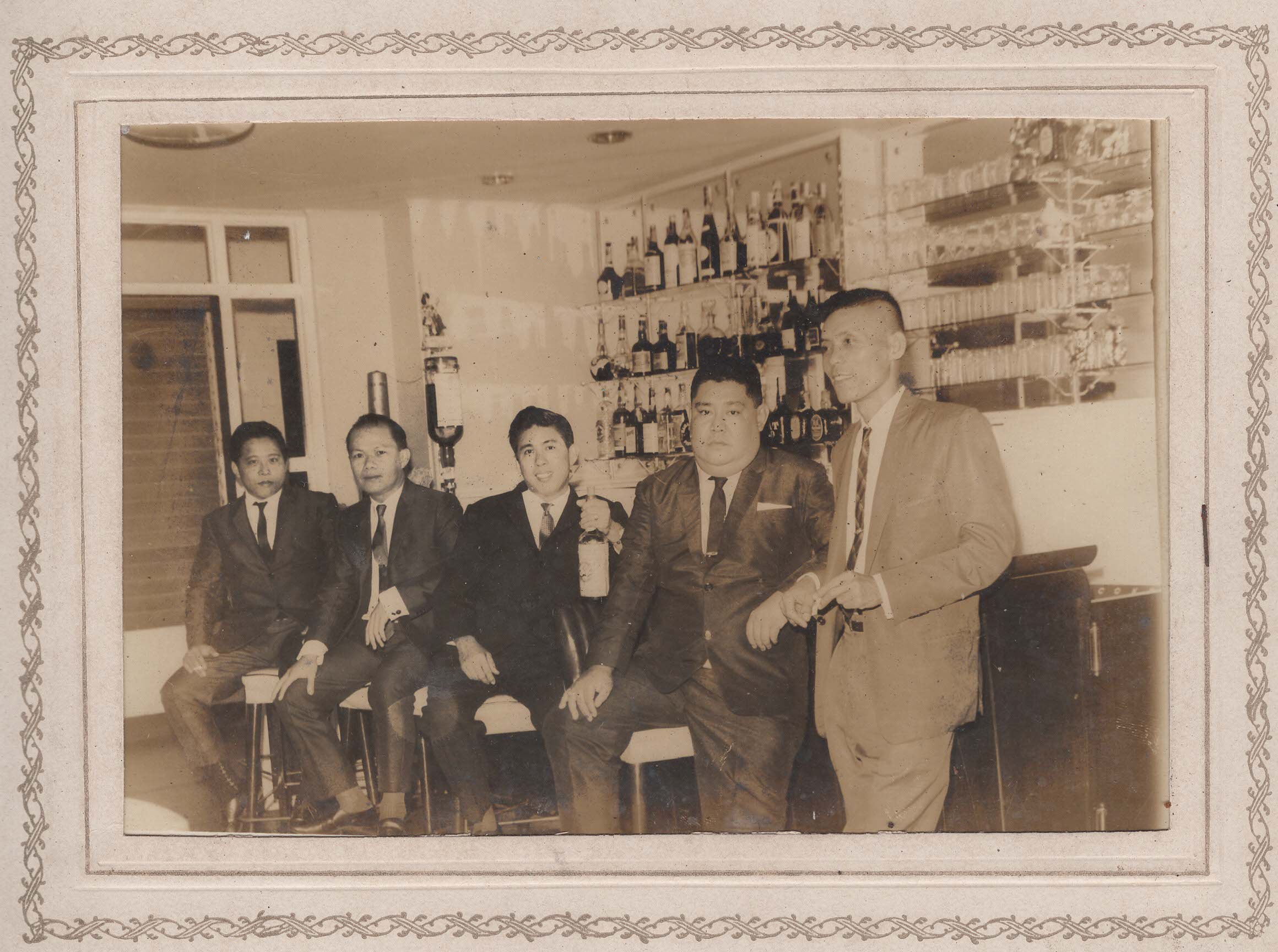 Five men gathered at a well-stocked bar